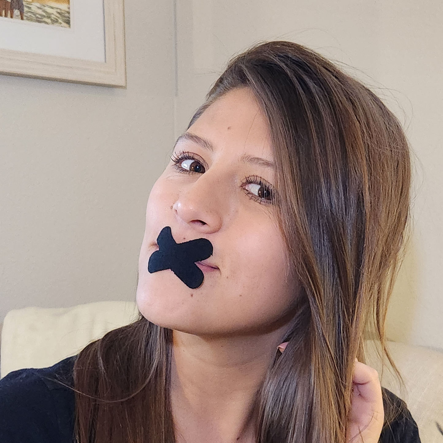 a woman with a black tape over her mouth